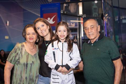 Retrato de família e laços de afeto na celebração de 6 anos da Anna. O carinho e a união dos pais e convidados durante o momento dos parabéns.'