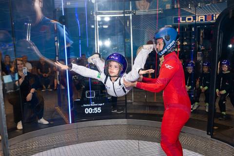 Registro lúdico e dinâmico de infância. Anna comemorando o aniversário de 6 anos com voo livre no túnel de vento do iFly, Distrito Federal.'