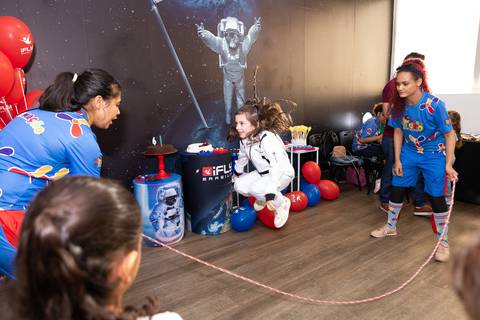 Registro lúdico e dinâmico de infância. Anna comemorando o aniversário de 6 anos com voo livre no túnel de vento do iFly, Distrito Federal.'