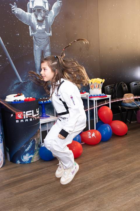 Registro lúdico e dinâmico de infância. Anna comemorando o aniversário de 6 anos com voo livre no túnel de vento do iFly, Distrito Federal.'