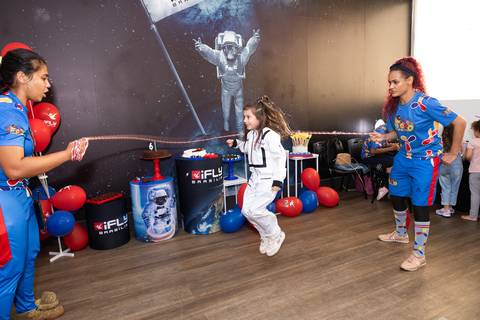 Registro lúdico e dinâmico de infância. Anna comemorando o aniversário de 6 anos com voo livre no túnel de vento do iFly, Distrito Federal.'