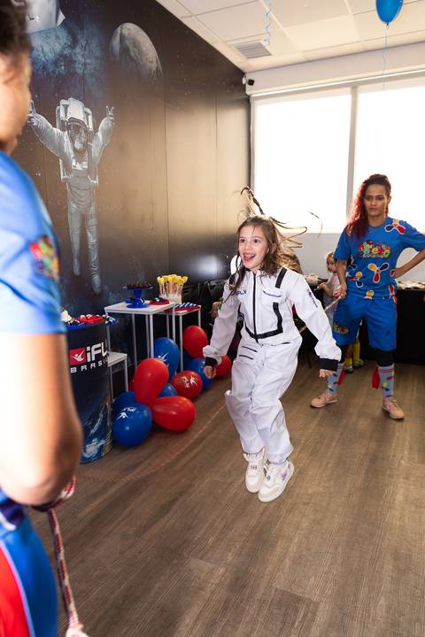 Registro lúdico e dinâmico de infância. Anna comemorando o aniversário de 6 anos com voo livre no túnel de vento do iFly, Distrito Federal.'