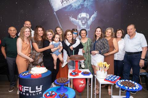 Retrato de família e laços de afeto na celebração de 6 anos da Anna. O carinho e a união dos pais e convidados durante o momento dos parabéns.'