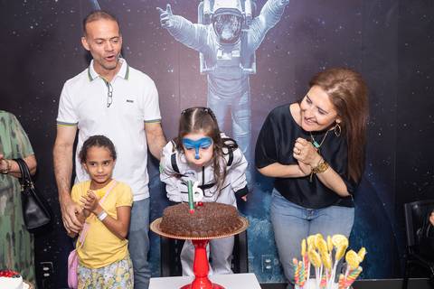 Retrato de família e laços de afeto na celebração de 6 anos da Anna. O carinho e a união dos pais e convidados durante o momento dos parabéns.'
