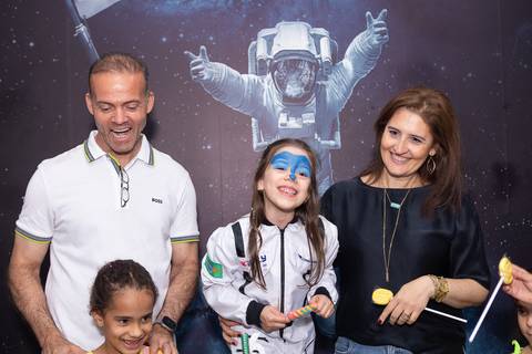 Retrato de família e laços de afeto na celebração de 6 anos da Anna. O carinho e a união dos pais e convidados durante o momento dos parabéns.'
