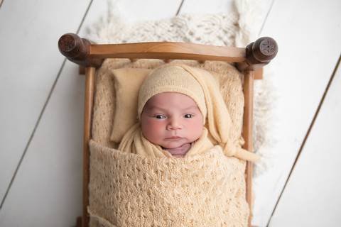 Ensaio newborn em estúdio. O recém-nascido Rafael em produções clássicas e minimalistas com gorrinhos, wraps e cestos em tons neutros e azuis.'