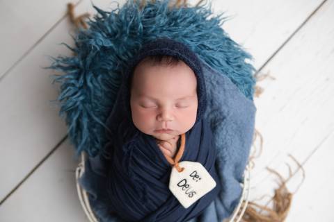 Ensaio newborn em estúdio. O recém-nascido Rafael em produções clássicas e minimalistas com gorrinhos, wraps e cestos em tons neutros e azuis.'