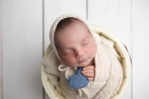 Ensaio newborn em estúdio. O recém-nascido Rafael em produções clássicas e minimalistas com gorrinhos, wraps e cestos em tons neutros e azuis.'
