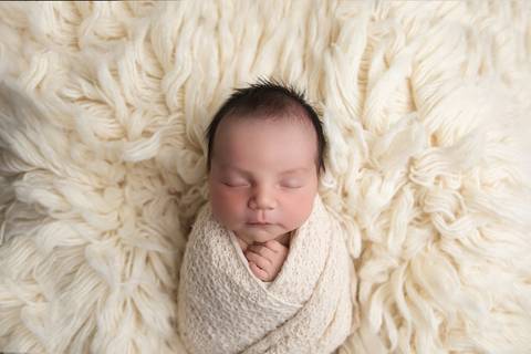 Ensaio newborn em estúdio. O recém-nascido Rafael em produções clássicas e minimalistas com gorrinhos, wraps e cestos em tons neutros e azuis.'