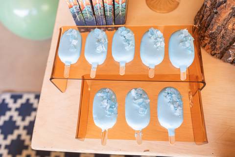 Detalhes da decoração temática de aniversário de 9 anos inspirada no livro Percy Jackson. Registro lúdico de doces personalizados e bolo do Acampamento Meio-Sangue em Brasília.'