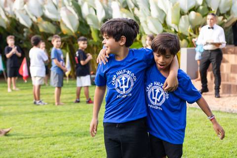 Crianças caracterizadas com camisetas de chalés mitológicos em festa infantil. Registro do desenvolvimento saudável e interação dos amigos no aniversário do Matheus.'