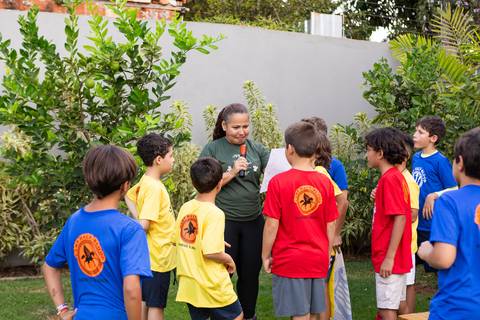 Crianças caracterizadas com camisetas de chalés mitológicos em festa infantil. Registro do desenvolvimento saudável e interação dos amigos no aniversário do Matheus.'