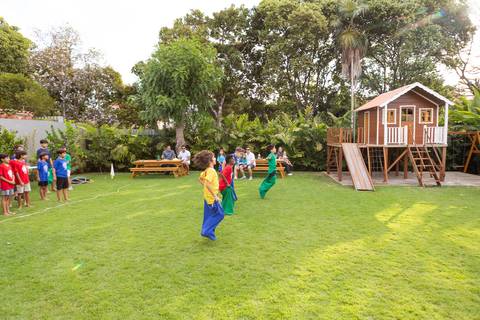 Brincadeiras e gincanas ao ar livre em aniversário infantil. Registro dinâmico de corrida de saco e atividades recreativas focadas no bem-estar e na diversão em Brasília.'