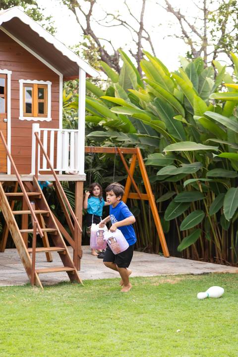 Brincadeiras e gincanas ao ar livre em aniversário infantil. Registro dinâmico de corrida de saco e atividades recreativas focadas no bem-estar e na diversão em Brasília.'