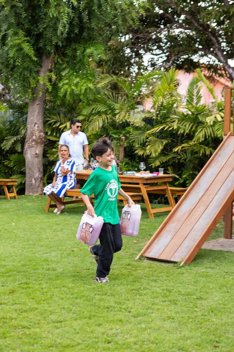 Brincadeiras e gincanas ao ar livre em aniversário infantil. Registro dinâmico de corrida de saco e atividades recreativas focadas no bem-estar e na diversão em Brasília.'