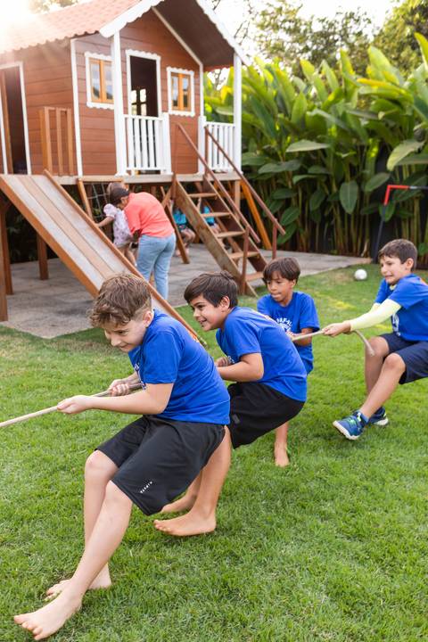 Brincadeiras e gincanas ao ar livre em aniversário infantil. Registro dinâmico de corrida de saco e atividades recreativas focadas no bem-estar e na diversão em Brasília.'