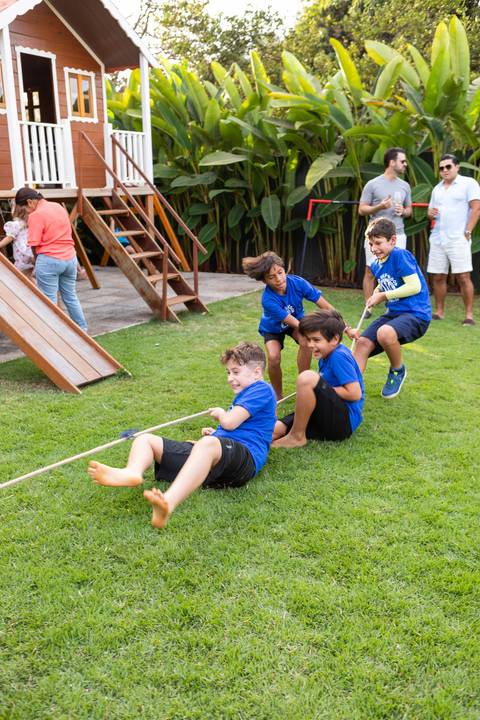 Brincadeiras e gincanas ao ar livre em aniversário infantil. Registro dinâmico de corrida de saco e atividades recreativas focadas no bem-estar e na diversão em Brasília.'