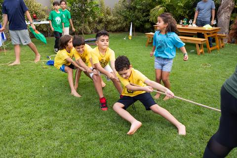 Brincadeiras e gincanas ao ar livre em aniversário infantil. Registro dinâmico de corrida de saco e atividades recreativas focadas no bem-estar e na diversão em Brasília.'