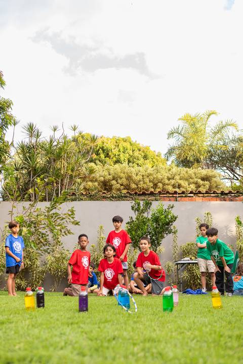 Brincadeiras e gincanas ao ar livre em aniversário infantil. Registro dinâmico de corrida de saco e atividades recreativas focadas no bem-estar e na diversão em Brasília.'