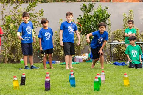 Brincadeiras e gincanas ao ar livre em aniversário infantil. Registro dinâmico de corrida de saco e atividades recreativas focadas no bem-estar e na diversão em Brasília.'