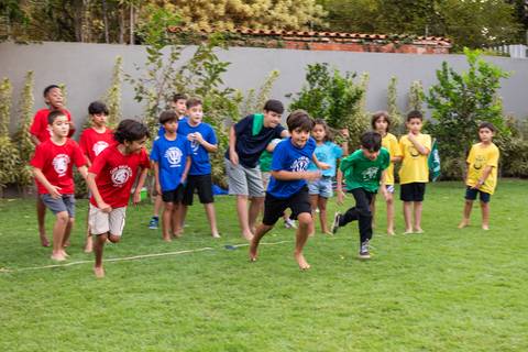 Atividades educativas e lúdicas em comemoração infantil de 9 anos. Crianças participando de jogo de perguntas e respostas com botão rápido durante a festa do Matheus.'