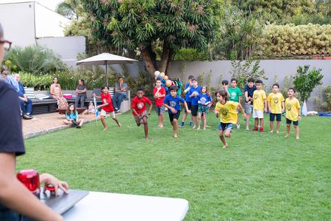 Atividades educativas e lúdicas em comemoração infantil de 9 anos. Crianças participando de jogo de perguntas e respostas com botão rápido durante a festa do Matheus.'