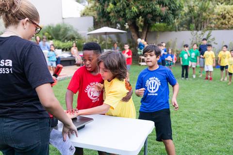 Atividades educativas e lúdicas em comemoração infantil de 9 anos. Crianças participando de jogo de perguntas e respostas com botão rápido durante a festa do Matheus.'