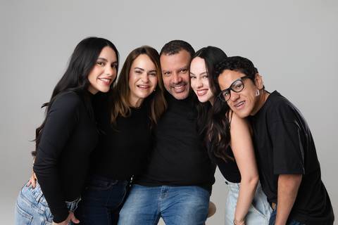 Retrato de família com cinco integrantes em Brasília. O casal, as filhas Isabela e Letícia, e o filho André reunidos em um abraço coletivo cheio de sintonia.'