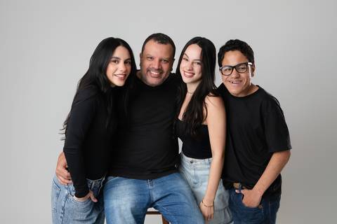 O pai com os três filhos reunidos no estúdio. Isabela, Letícia e André em um momento de descontração e sorrisos com o pai.'