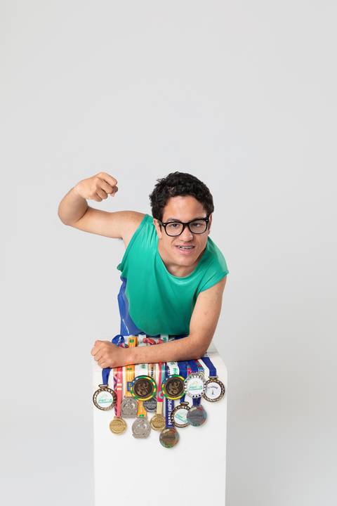 O orgulho do esporte paralímpico. André exibindo suas medalhas de atletismo em uma pose dinâmica e cheia de orgulho e vitória no DF.'