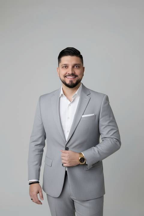 Retrato empresarial masculino em Brasília. Consultor de carreira vestindo terno cinza-claro em imagem moderna para site institucional.'