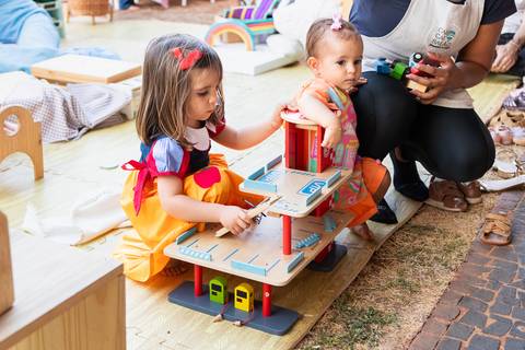 Brincadeiras e interações lúdicas em aniversário infantil de 3 anos. A aniversariante Liz se divertindo com oficinas criativas, casinha de brinquedo e atividades recreativas.'