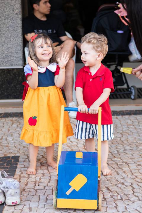 Momentos espontâneos de carinho e convívio familiar na infância. Liz e seus amigos compartilhando risadas e afeto durante festa temática em Brasília.'