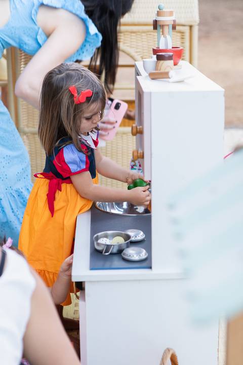 Brincadeiras e interações lúdicas em aniversário infantil de 3 anos. A aniversariante Liz se divertindo com oficinas criativas, casinha de brinquedo e atividades recreativas.'
