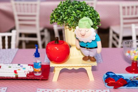 Detalhes da decoração infantil de 3 anos inspirada no tema Branca de Neve. Registro lúdico com doces personalizados, bolo temático e elementos do bosque em Brasília.'