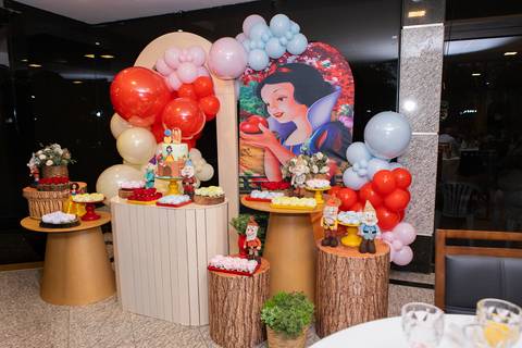 Detalhes da decoração infantil de 3 anos inspirada no tema Branca de Neve. Registro lúdico com doces personalizados, bolo temático e elementos do bosque em Brasília.'