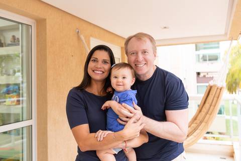 União e felicidade em família. Os pais Mariana e Vincenzo com a pequena Cecília no colo, vestindo roupas coordenadas em tons de azul.'