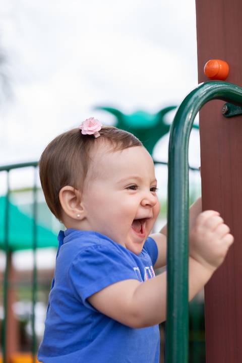Expressões espontâneas e pureza da infância. Bebê Cecília esbanjando sorrisos em tarde de lazer e atividades saudáveis.'