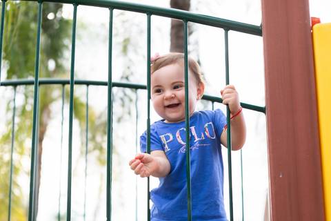 Olhares curiosos e interação com o ambiente. Cecília esbanjando alegria durante momentos de recreação infantil no parquinho.'