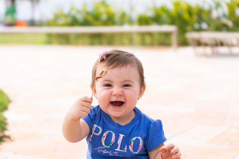 A doçura e a vivacidade do primeiro ano de vida. Retrato focado na pureza e na felicidade da bebê Cecília em comemoração familiar.'