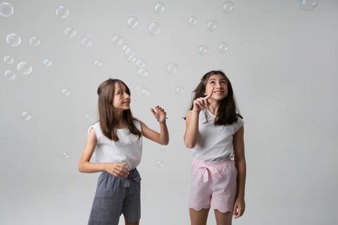 Atividades criativas, música e a essência da juventude. Meninas interagindo com fone de ouvido, canetas coloridas e elementos lúdicos no estúdio.'