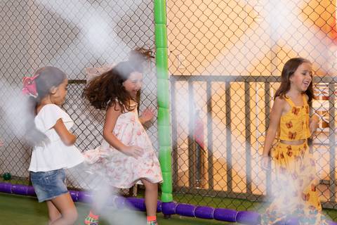 Aventura, movimento e pura diversão na infância. Crianças se divertindo na tirolesa e na piscina de bolinhas durante comemoração de aniversário.'