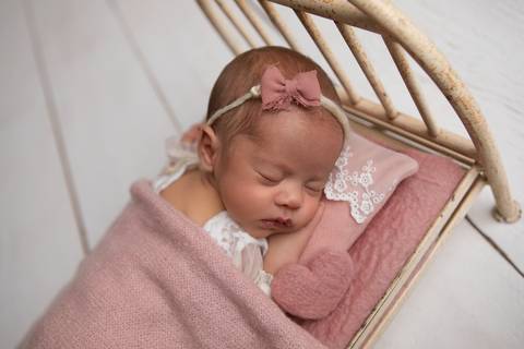 Doçura e tranquilidade nos primeiros dias de vida da Laura. Bebê descansando em produções delicadas com tons de lilás, rosa-velho e mantas suaves.'