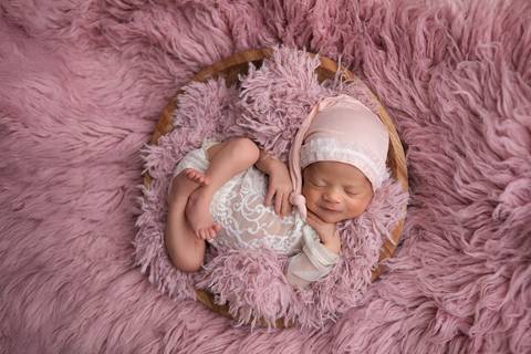 Doçura e tranquilidade nos primeiros dias de vida da Laura. Bebê descansando em produções delicadas com tons de lilás, rosa-velho e mantas suaves.'