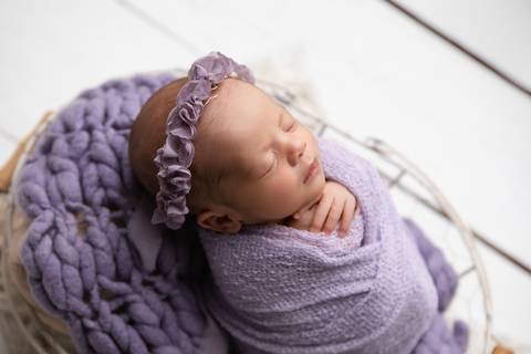 Doçura e tranquilidade nos primeiros dias de vida da Laura. Bebê descansando em produções delicadas com tons de lilás, rosa-velho e mantas suaves.'
