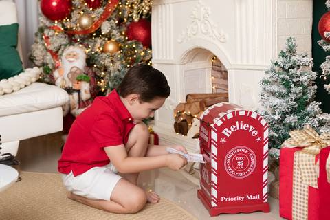 Imaginação e pureza no desenvolvimento infantil. Benhur postando sua cartinha na caixa de correio temática de Natal no DF.'