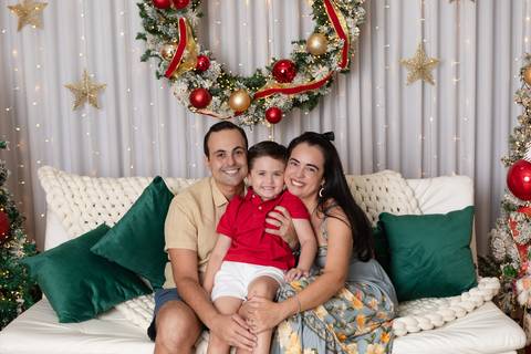 Retrato de família e união em comemoração tradicional. O casal e o filho juntos no sofá em momento repleto de carinho e harmonia.'