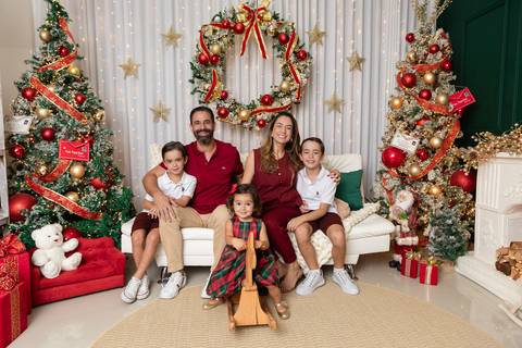 Retrato de família com cinco integrantes no Distrito Federal. Caroline e Leonardo cercados pelo afeto dos filhos Davi, Lucas e Beatriz em comemoração tradicional.'