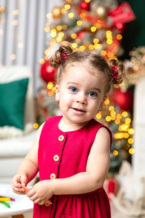 Pureza e expressões espontâneas do bebê. A pequena Olívia esbanjando doçura com vestido festivo em ambiente acolhedor no Distrito Federal.'