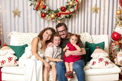 Retrato de família e laços de amor. Hanna, Diego e os filhos Miguel e Olívia reunidos em um abraço carinhoso com trajes coordenados.'